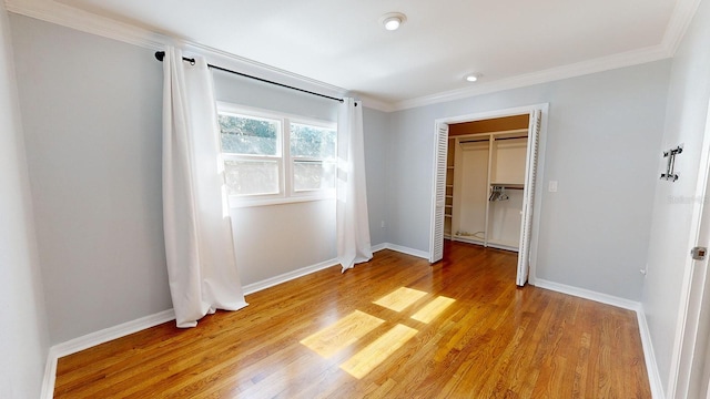 unfurnished bedroom featuring light hardwood / wood-style floors, ornamental molding, and a closet