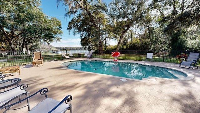 view of swimming pool with a water view and a patio area