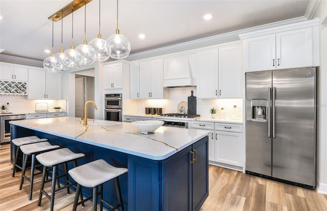 kitchen featuring an island with sink, white cabinetry, and stainless steel appliances