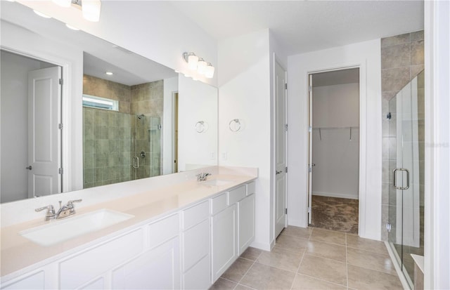 bathroom with tile patterned flooring, vanity, and a shower with door