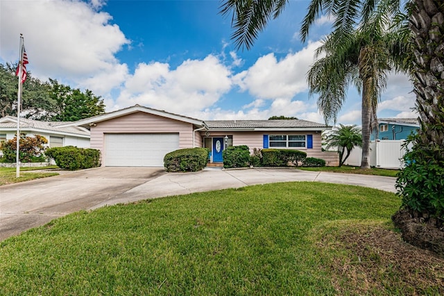 ranch-style home with a front yard, concrete driveway, fence, and an attached garage