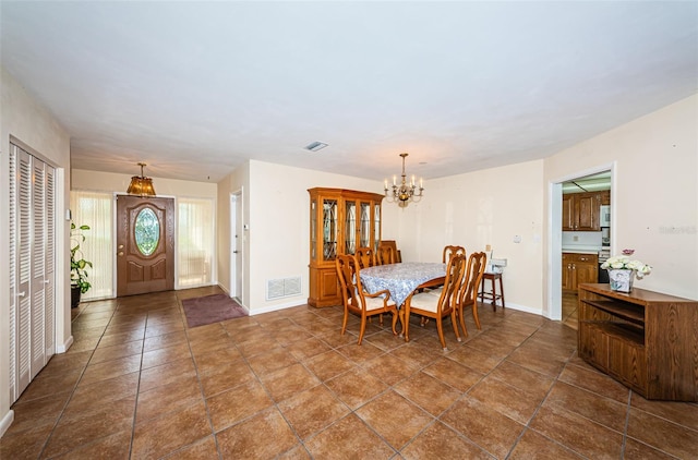 dining room featuring an inviting chandelier, baseboards, and visible vents