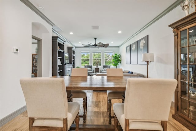 dining room with crown molding, hardwood / wood-style floors, and ceiling fan