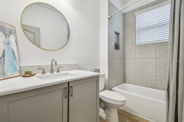 full bathroom featuring hardwood / wood-style floors, vanity, shower / tub combo, and toilet