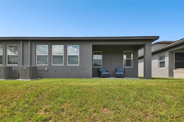 rear view of property with a yard, a patio, central AC, and an outdoor hangout area