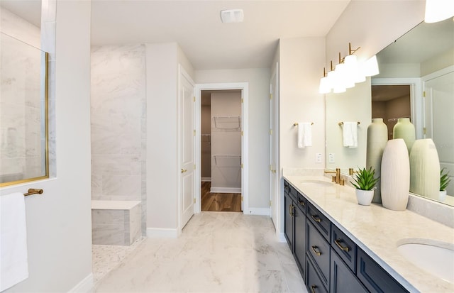 bathroom featuring a tile shower and vanity