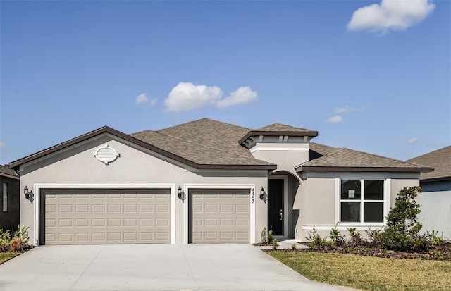 view of front of property with a shingled roof, concrete driveway, a front yard, stucco siding, and a garage