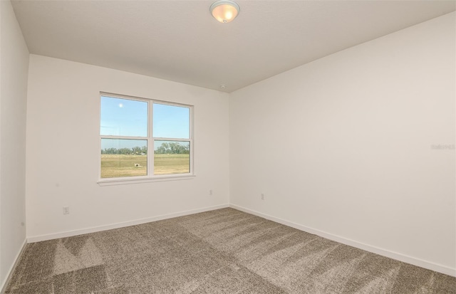 carpeted spare room featuring baseboards