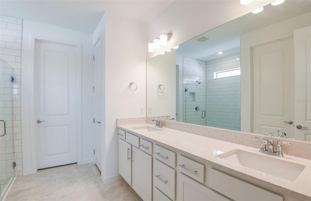 bathroom with double vanity, visible vents, a shower stall, and a sink