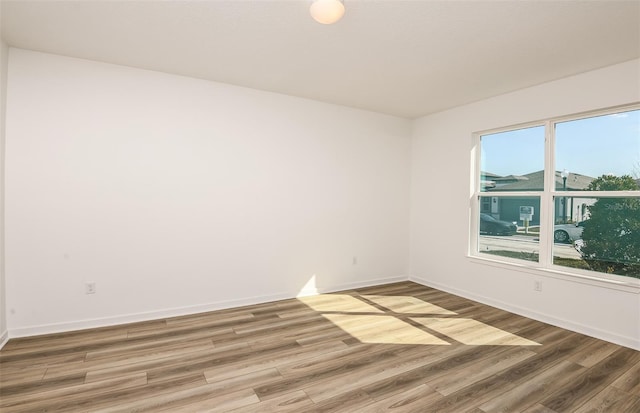 unfurnished room with light wood-style floors and baseboards
