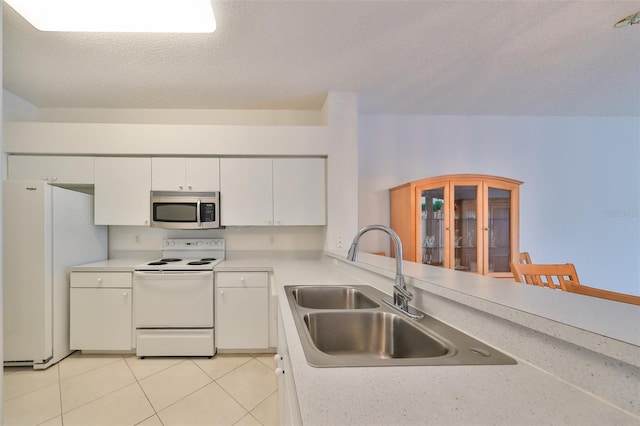 kitchen with white cabinets, a textured ceiling, sink, light tile patterned flooring, and white appliances