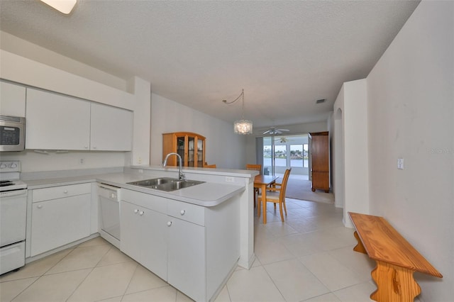 kitchen featuring white cabinetry, decorative light fixtures, white appliances, sink, and kitchen peninsula