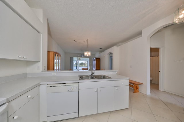 kitchen with white dishwasher, kitchen peninsula, sink, white cabinetry, and decorative light fixtures