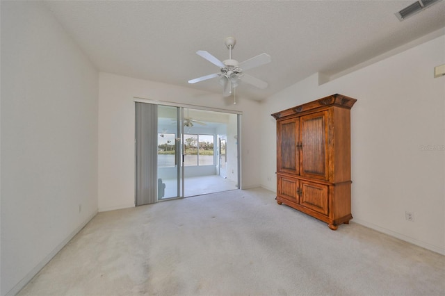 carpeted spare room featuring a textured ceiling and ceiling fan