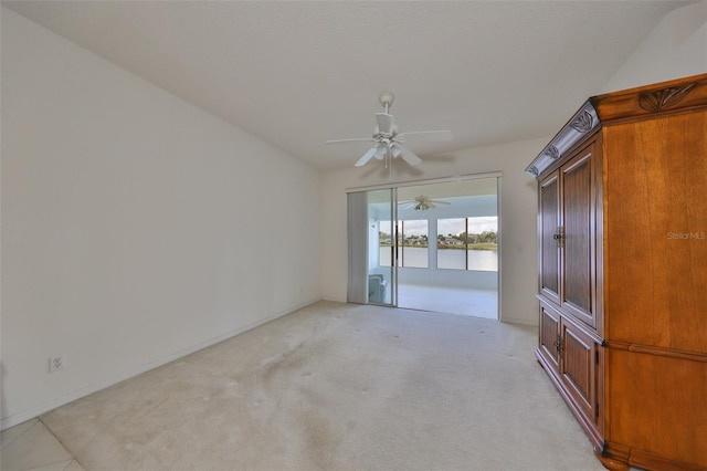 empty room with ceiling fan, light carpet, and a water view