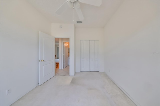 unfurnished bedroom featuring a closet, light colored carpet, and ceiling fan