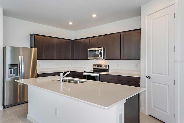 kitchen featuring appliances with stainless steel finishes, sink, a center island with sink, and light tile patterned floors