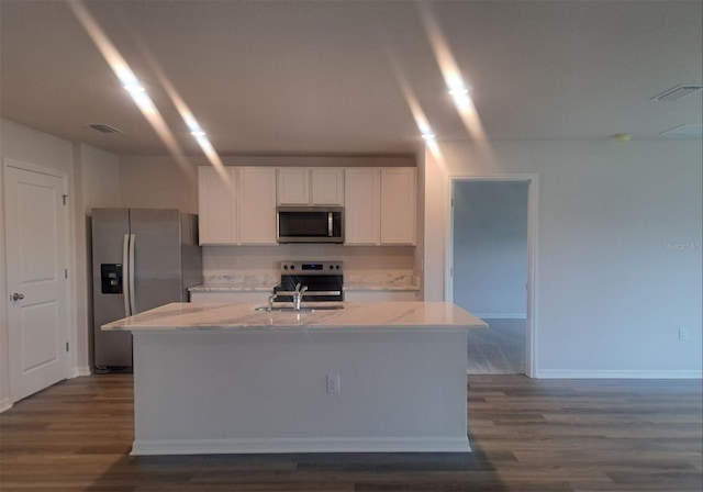 kitchen featuring light stone counters, white cabinetry, a center island with sink, and stainless steel appliances