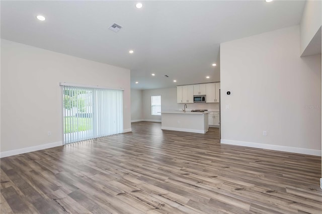 unfurnished living room with light hardwood / wood-style flooring and sink