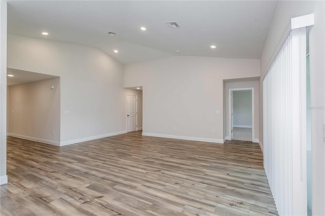 unfurnished room featuring high vaulted ceiling and light hardwood / wood-style floors