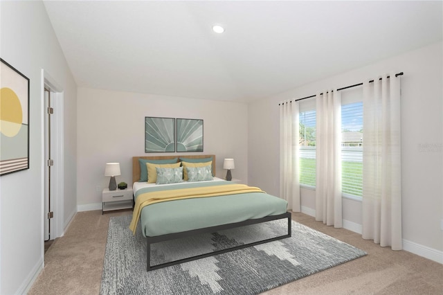 bedroom with light colored carpet and baseboards