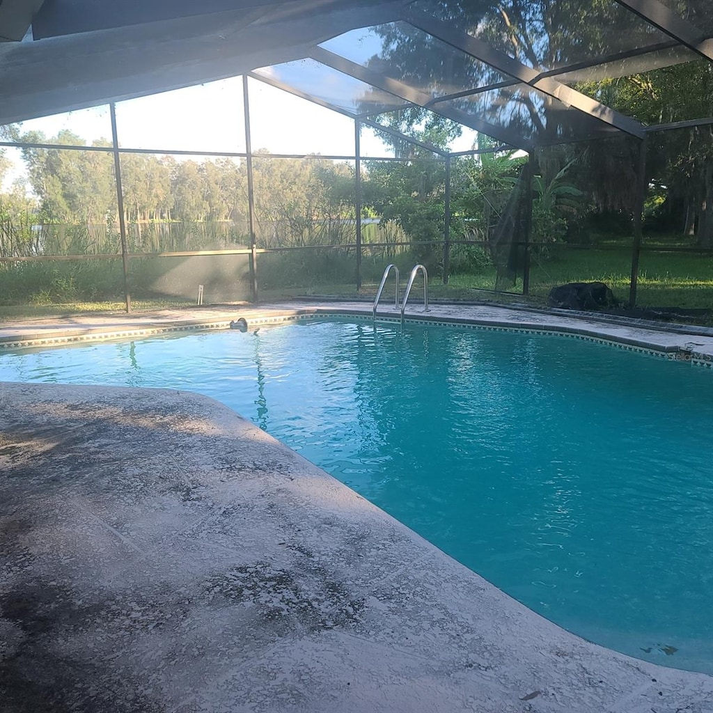 view of swimming pool with a lanai