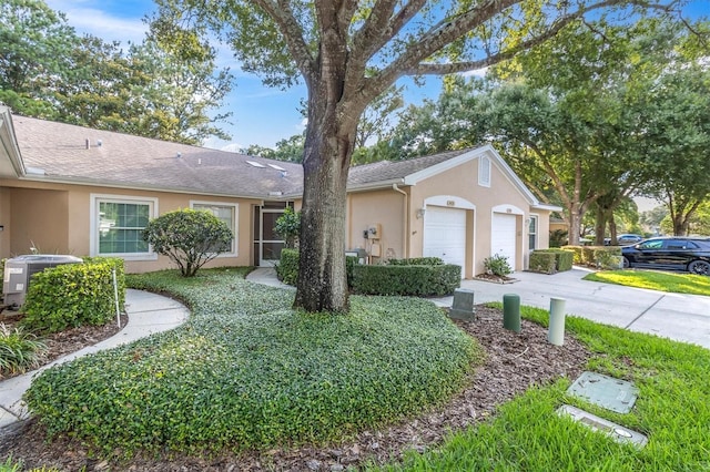 ranch-style home with a garage and central air condition unit