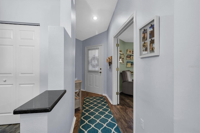 hallway featuring vaulted ceiling and dark hardwood / wood-style floors