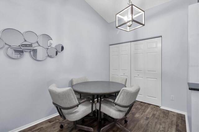 dining space featuring vaulted ceiling, dark hardwood / wood-style floors, and a notable chandelier