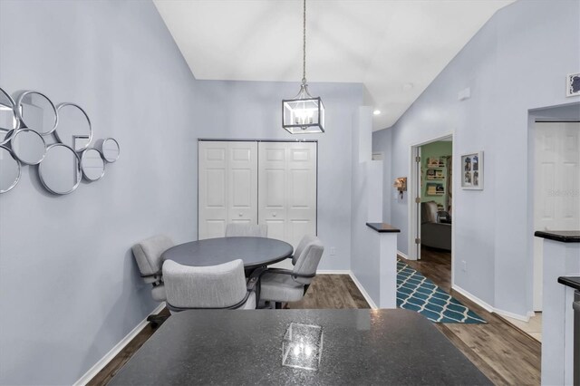 dining room featuring lofted ceiling and dark wood-type flooring