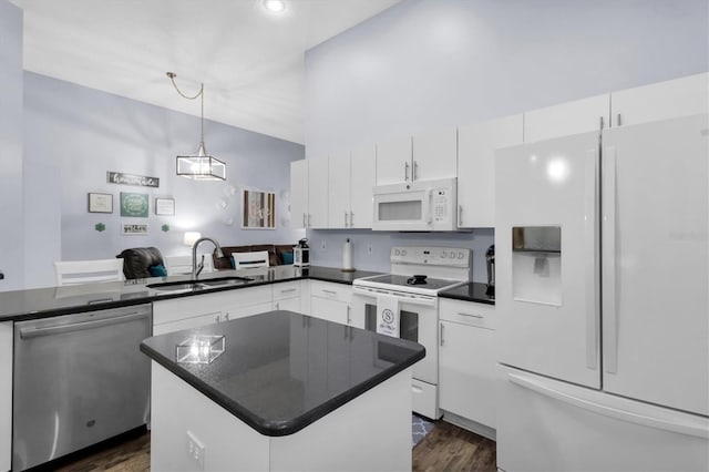 kitchen with hanging light fixtures, dark wood-type flooring, white cabinets, white appliances, and sink