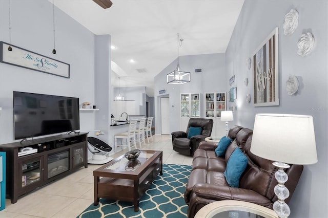 living room featuring a towering ceiling, a chandelier, light tile patterned floors, and sink