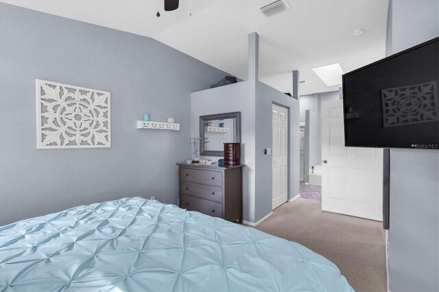 bedroom with vaulted ceiling, a closet, and light colored carpet