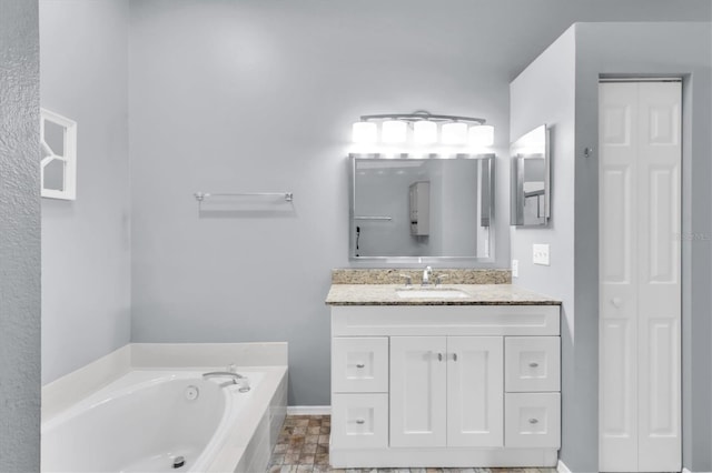 bathroom featuring tiled bath and vanity