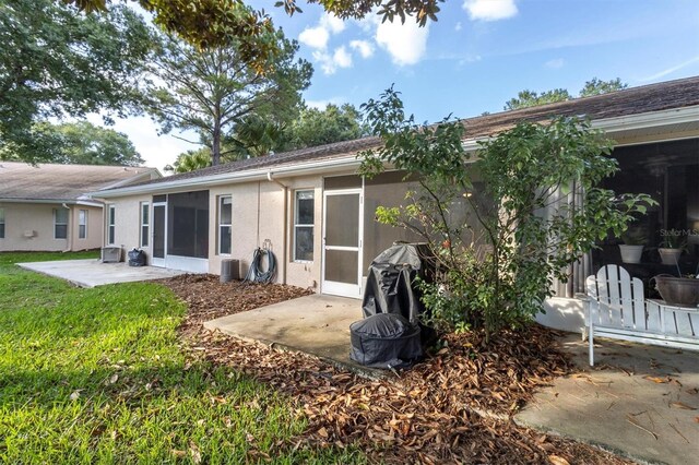 rear view of property with a sunroom and a patio area