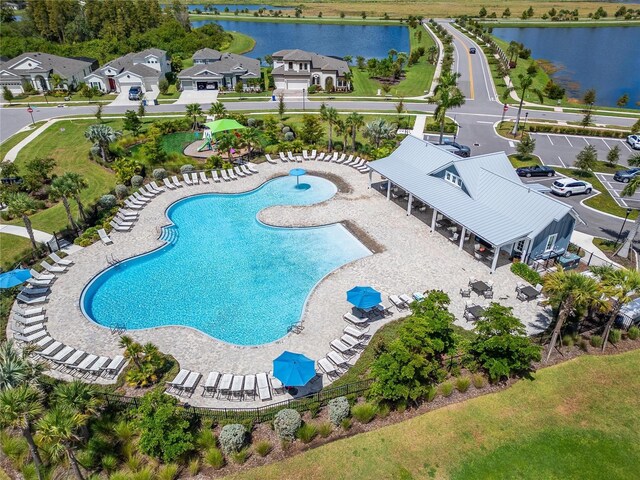 view of pool with a water view and a patio area