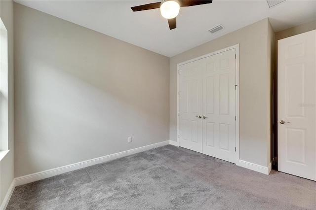 unfurnished bedroom featuring light colored carpet, ceiling fan, and a closet