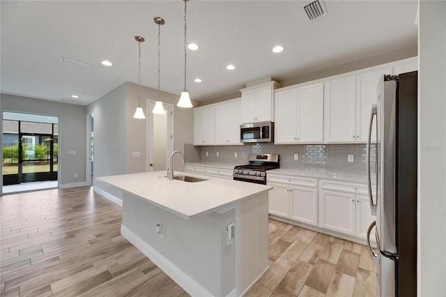 kitchen featuring white cabinetry, appliances with stainless steel finishes, sink, and a center island with sink