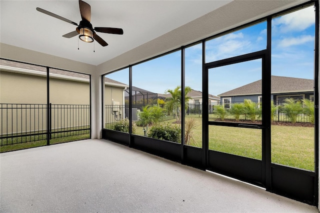 unfurnished sunroom featuring ceiling fan