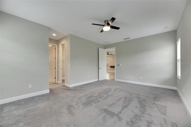 unfurnished room with light colored carpet and ceiling fan