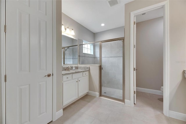 bathroom featuring an enclosed shower, vanity, tile patterned flooring, and toilet