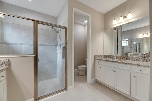 bathroom featuring vanity, toilet, a shower with shower door, and tile patterned flooring