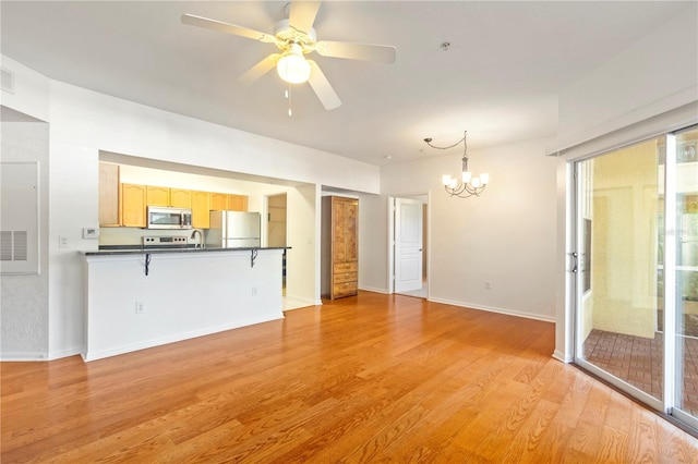 unfurnished living room featuring ceiling fan with notable chandelier, light wood-type flooring, and sink