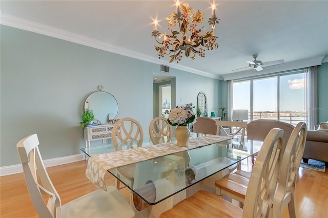 dining space with ornamental molding, ceiling fan with notable chandelier, and light hardwood / wood-style floors