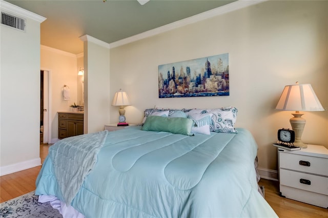 bedroom with light hardwood / wood-style flooring, connected bathroom, and crown molding