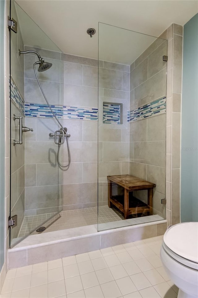 bathroom with a shower with door and toilet