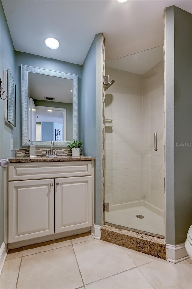 bathroom featuring vanity, a shower with shower door, tile patterned flooring, and toilet