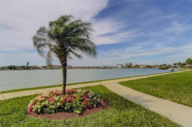 surrounding community with a water view and a yard