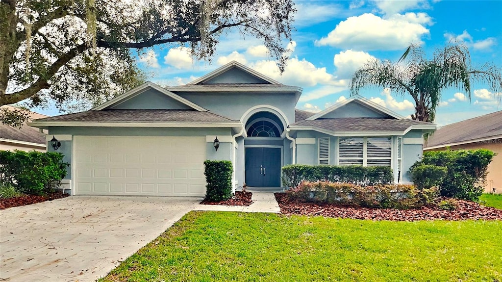 view of front of property with a front yard and a garage