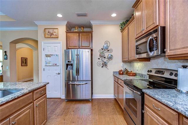 kitchen with tasteful backsplash, ornamental molding, light hardwood / wood-style floors, stainless steel appliances, and light stone countertops